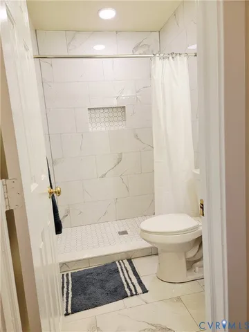 a bathroom with a toilet and a shower