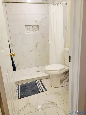 a bathroom with a toilet and a shower