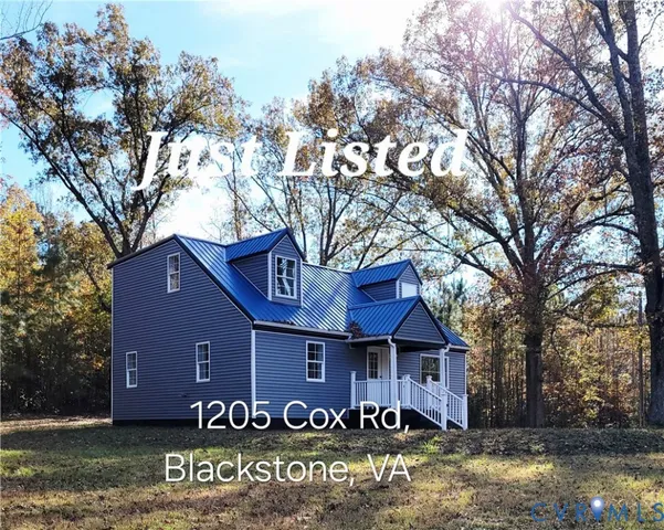 a front view of a house with yard and large trees