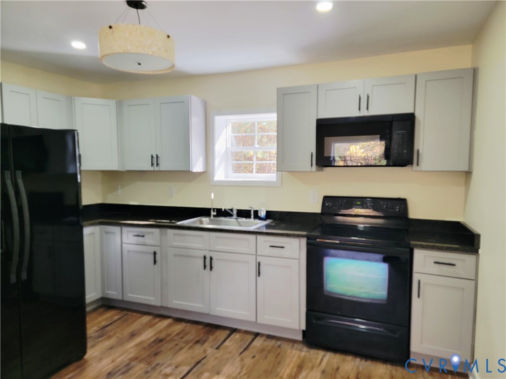 1205 Cox Road Blackstone, VA 23824 - Photo 25 of 29 a kitchen with stainless steel appliances granite countertop a stove a sink and a microwave