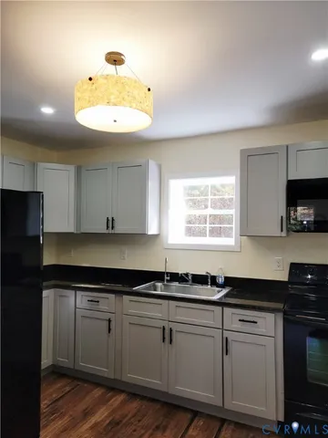 a kitchen with granite countertop a sink a window stainless steel appliances and cabinets