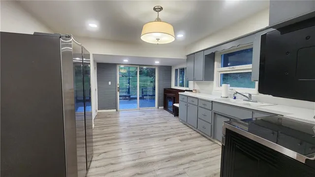 a kitchen with stainless steel appliances granite countertop a sink cabinets and wooden floor