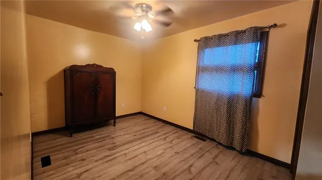 an empty room with wooden floor and closet area
