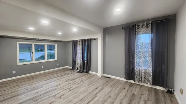 an empty room with windows and closet