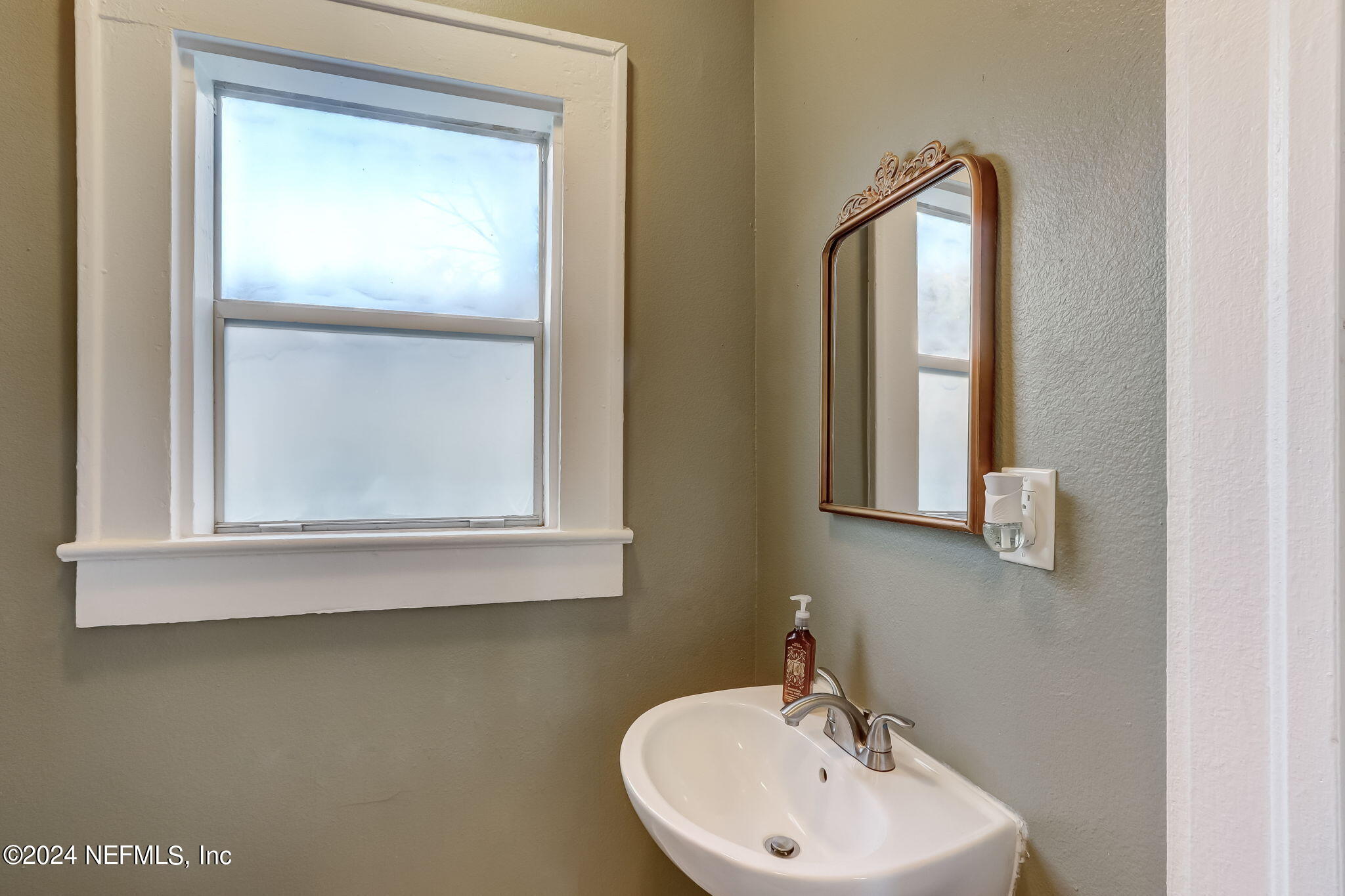5316 Colonial Avenue Jacksonville, FL 32210 - Photo 25 of 30 a bathroom with a sink and a mirror