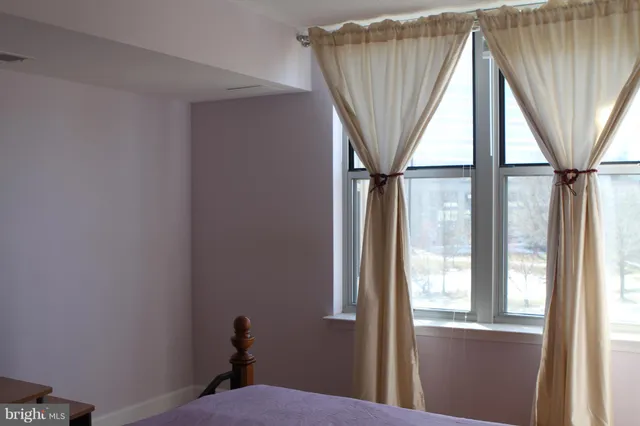 a view of a room that has a window and a ceiling fan