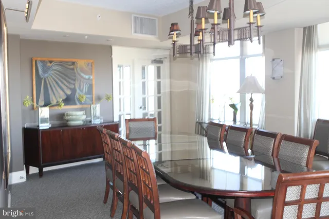 a dining room with furniture a chandelier and wooden floor