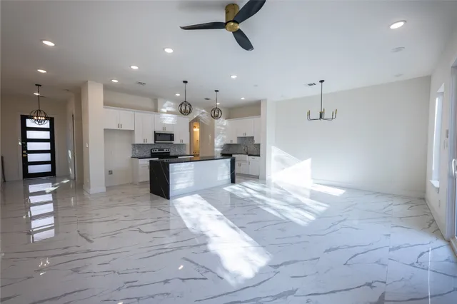 a view of kitchen with kitchen island stainless steel appliances refrigerator stove microwave and cabinets