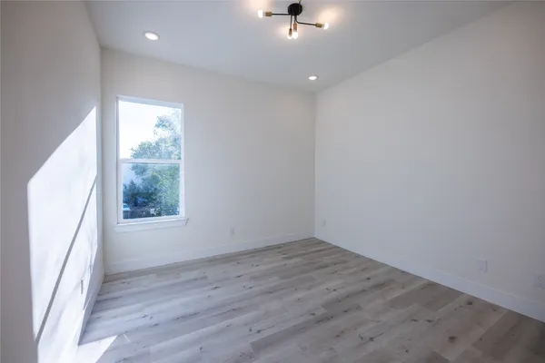 a view of a small space with wooden floor and a window