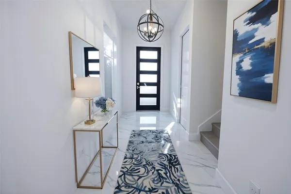 a view of a hallway with wooden floor and windows