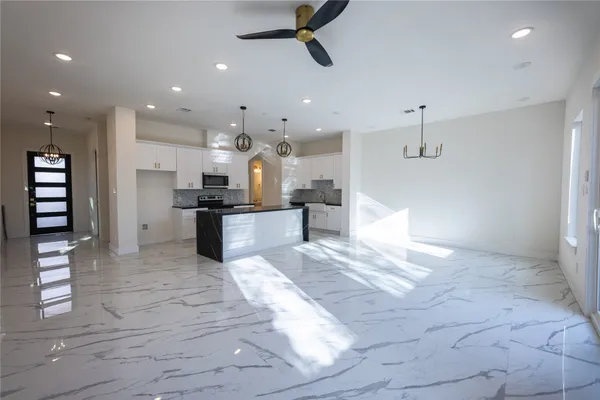 a view of kitchen with kitchen island stainless steel appliances refrigerator stove microwave and cabinets