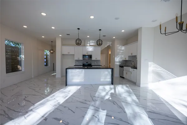 a view of kitchen with kitchen island sink and refrigerator