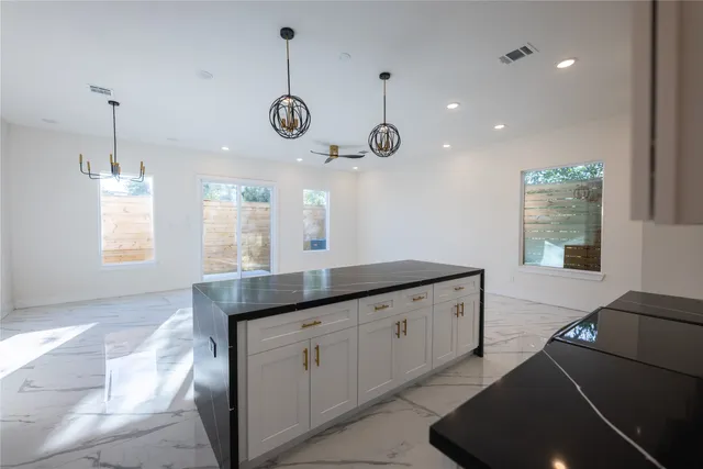 a kitchen with granite countertop cabinets a window and a sink