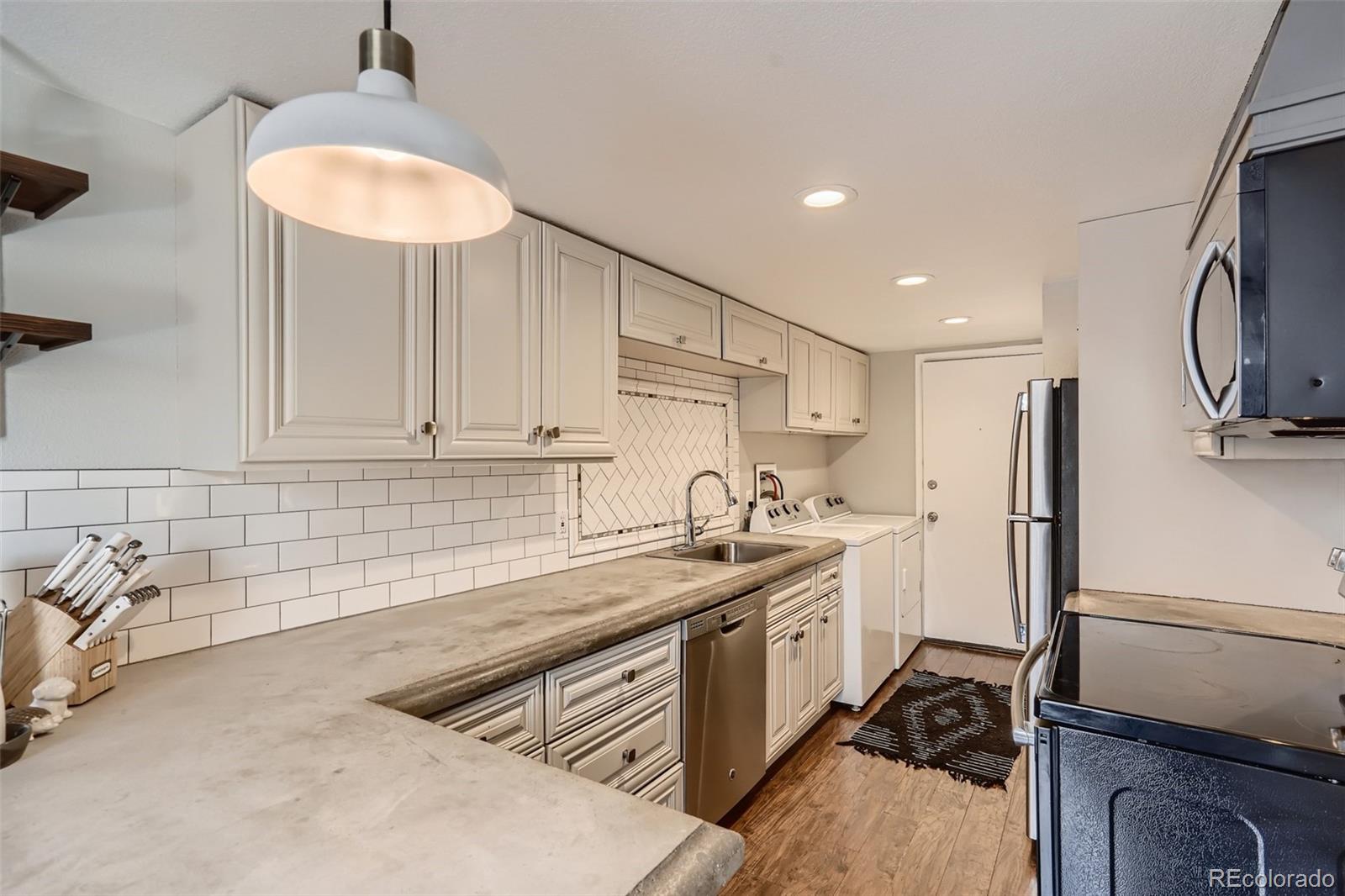 7972 Chase Circle, Unit 82 Arvada, CO 80003 - Photo 4 of 11 a kitchen with stainless steel appliances granite countertop a sink stove and refrigerator