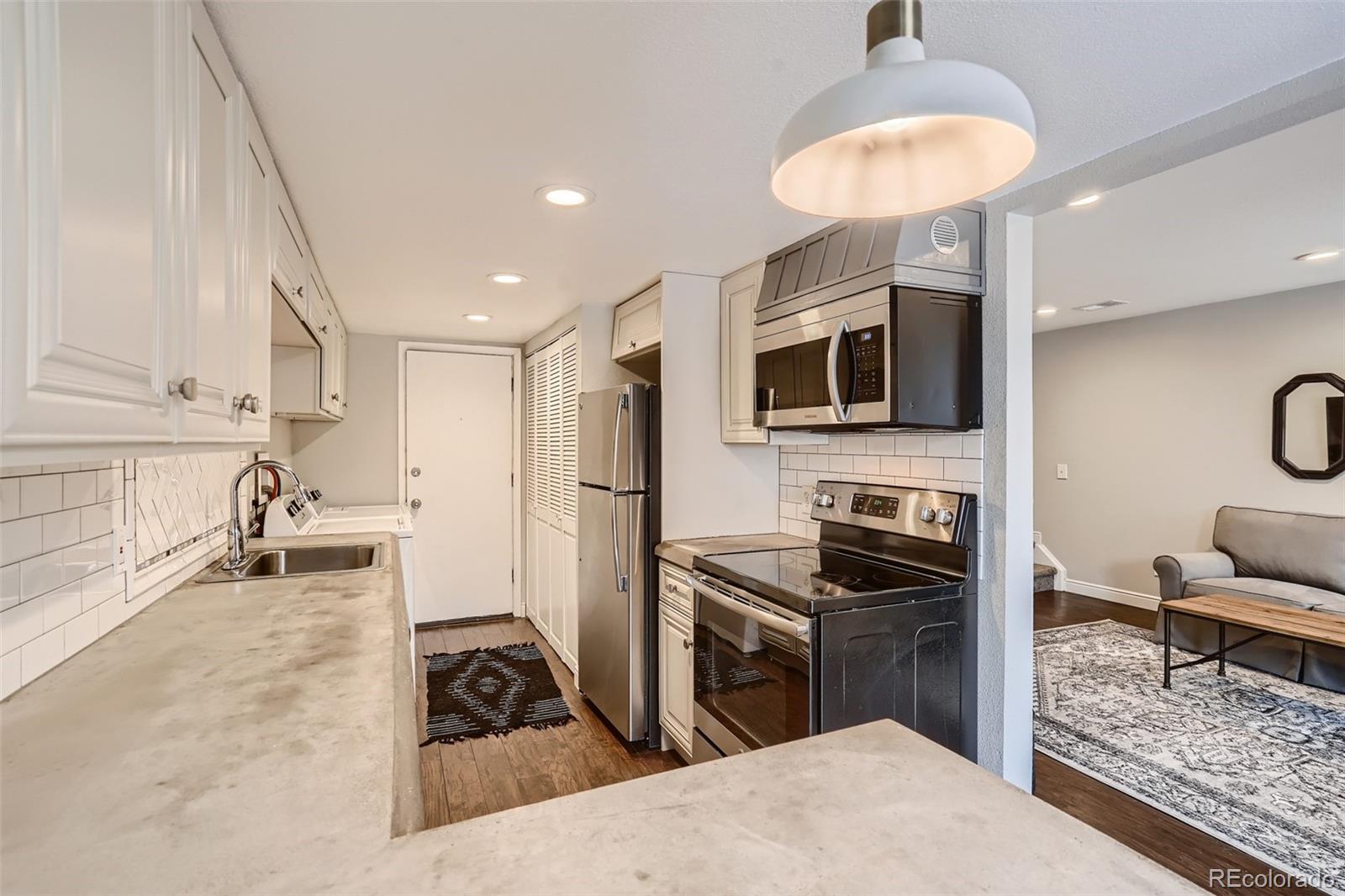 7972 Chase Circle, Unit 82 Arvada, CO 80003 - Photo 5 of 11 a kitchen with granite countertop a stove and a sink