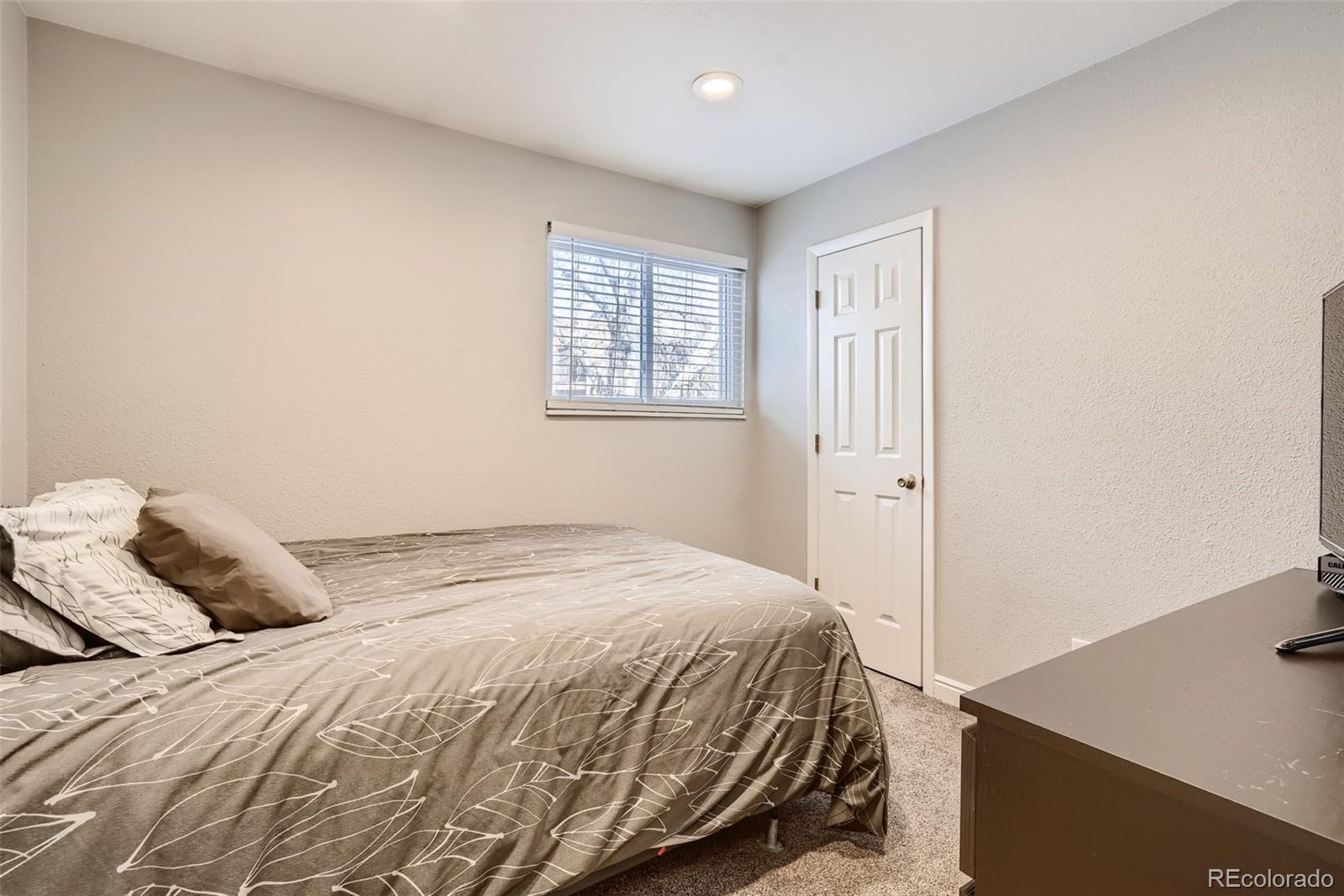 7972 Chase Circle, Unit 82 Arvada, CO 80003 - Photo 9 of 11 a bedroom with a bed and a window