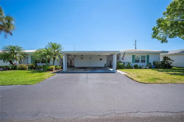 a view of a house with a yard and palm tree