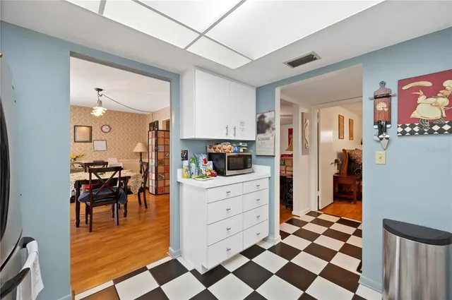 a kitchen with a checkered floor and white cabinets