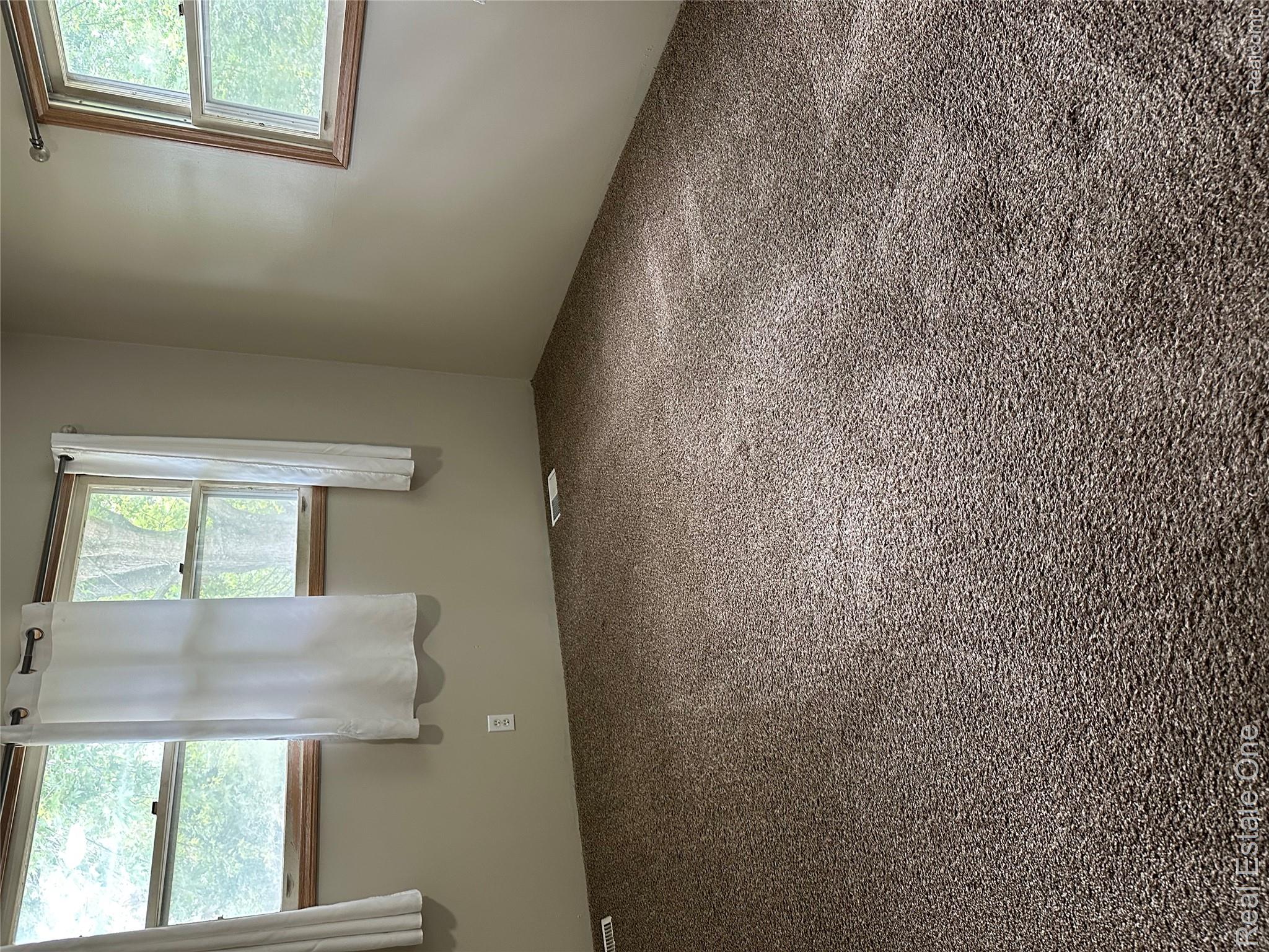2430 Coolidge Road Barryton, MI 49305 - Photo 16 of 29 Carpeted flooring with multiple windows featuring natural wood trim