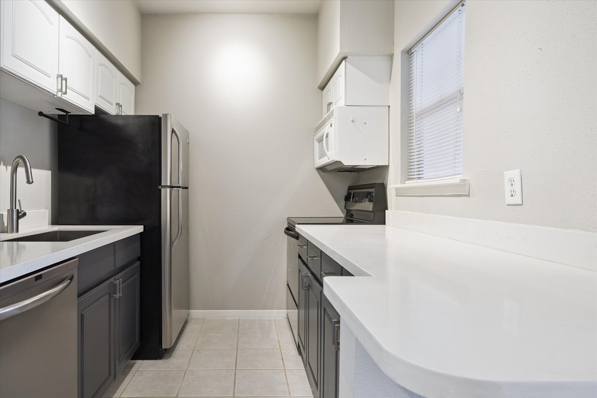 4041 Drake Street, Unit 113 Houston, TX 77005 - Photo 7 of 15 a kitchen with a sink and a refrigerator