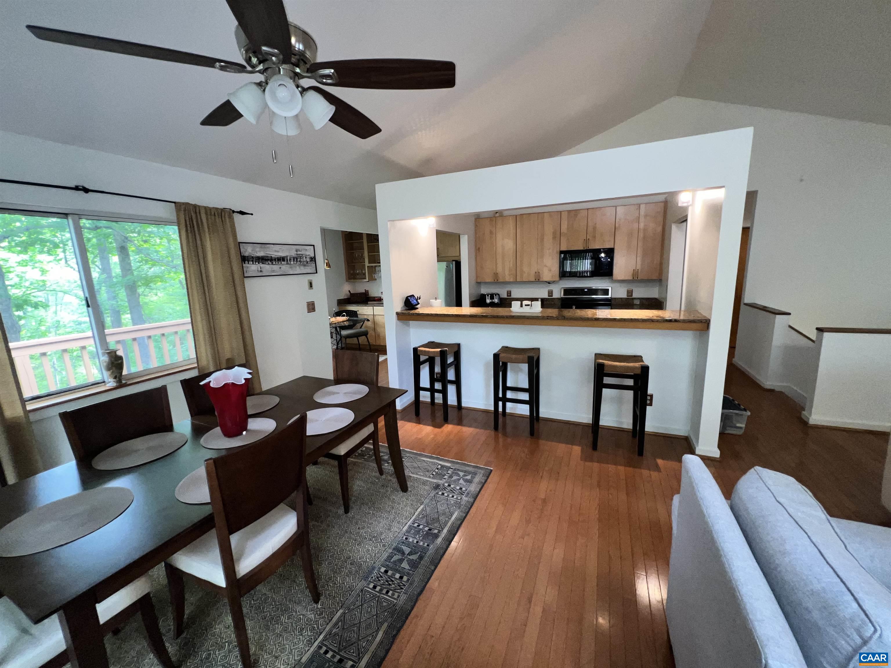 1663 Brandywine Drive Charlottesville, VA 22901 - Photo 2 of 16 a living room with stainless steel appliances a dining table a window and a flat screen tv