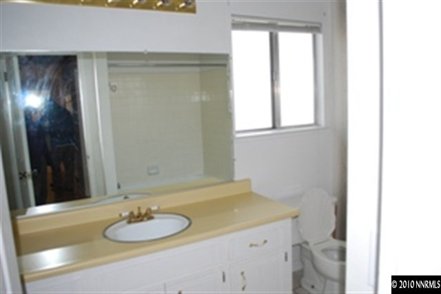 1950 Stardust Street Reno, NV 89503 - Photo 5 of 6 a bathroom with a granite countertop sink and a mirror