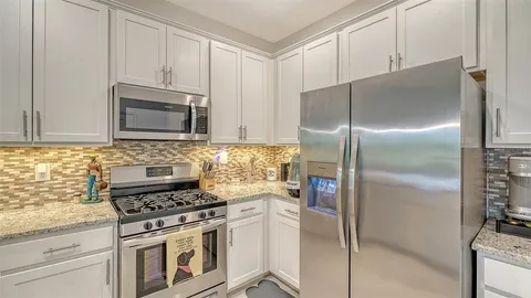 a kitchen with stainless steel appliances granite countertop a refrigerator stove and microwave