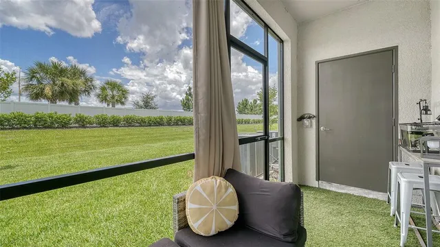 a living room with hardwood floor and a floor to ceiling window