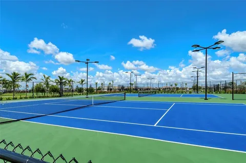 a view of a tennis ground with a large swimming pool