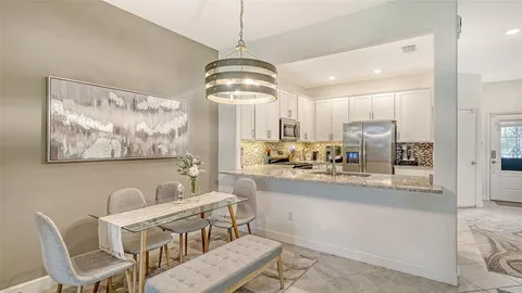 a view of dining room and kitchen with a chandelier