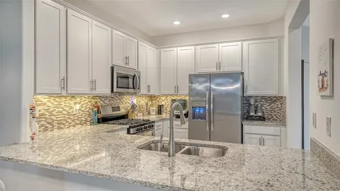 a kitchen with granite countertop a refrigerator and a sink