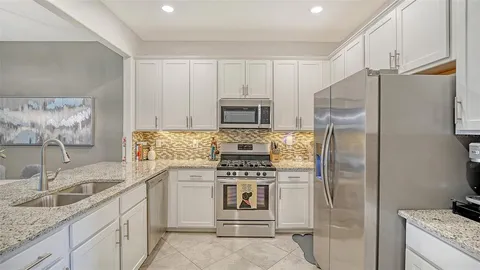 a kitchen with stainless steel appliances granite countertop a refrigerator and a sink