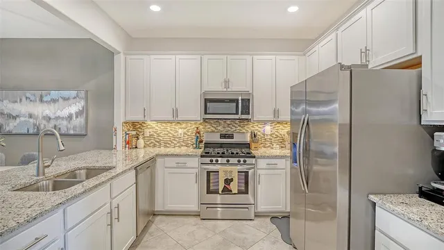 a kitchen with stainless steel appliances granite countertop a refrigerator and a sink