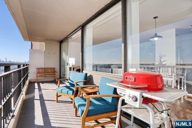 4 Horizon Road, Unit 1027 Fort Lee, NJ 07024 - Photo 12 of 38 a living room with furniture a rug and a view of kitchen