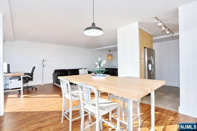 4 Horizon Road, Unit 1027 Fort Lee, NJ 07024 - Photo 14 of 38 a kitchen with a dining table chairs and white cabinets