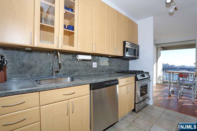 4 Horizon Road, Unit 1027 Fort Lee, NJ 07024 - Photo 17 of 38 a kitchen with stainless steel appliances granite countertop a sink stove and cabinets