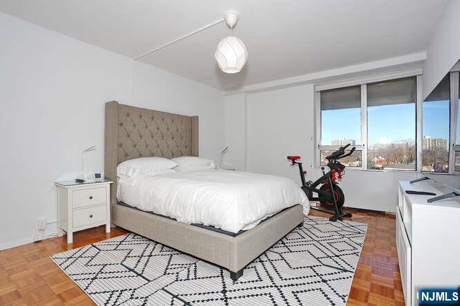 4 Horizon Road, Unit 1027 Fort Lee, NJ 07024 - Photo 19 of 38 a bedroom with a bed a table and chairs