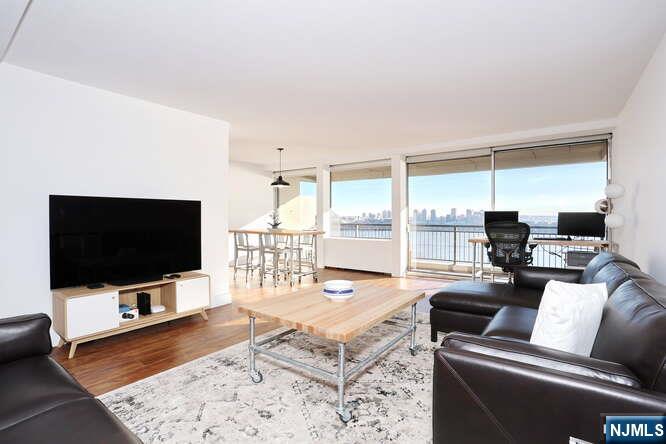 4 Horizon Road, Unit 1027 Fort Lee, NJ 07024 - Photo 7 of 38 a living room with furniture and a flat screen tv