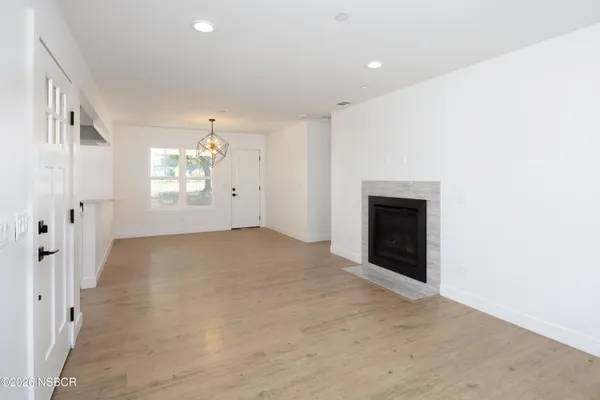 an empty room with windows and fireplace