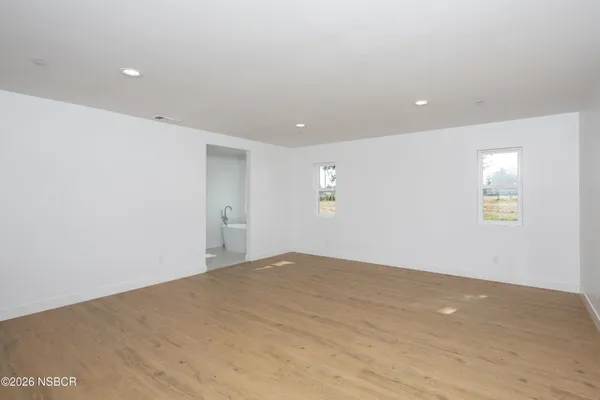 an empty room with windows and fireplace