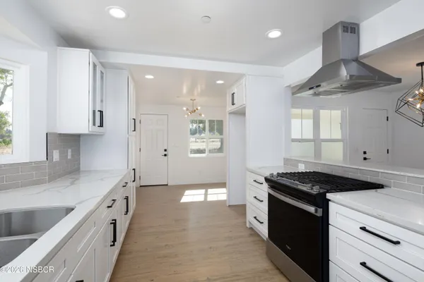 a kitchen with stainless steel appliances granite countertop a sink stove and cabinets