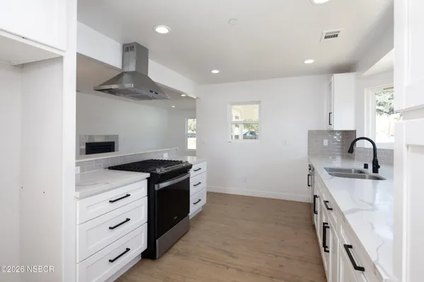 a kitchen with stainless steel appliances granite countertop a sink stove and cabinets