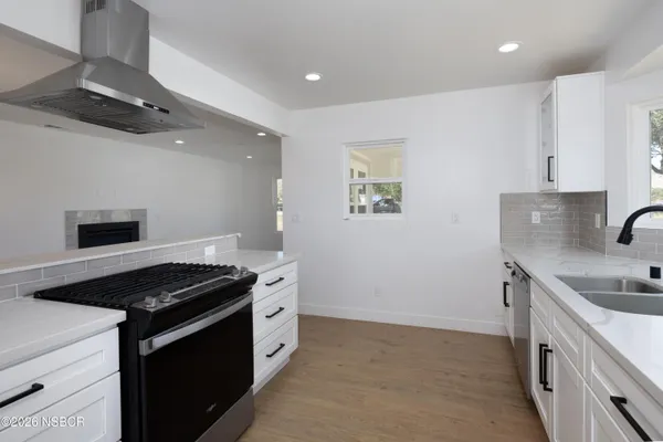 a kitchen with stainless steel appliances granite countertop a sink stove and cabinets