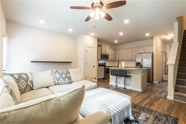 a living room with furniture kitchen view and a chandelier