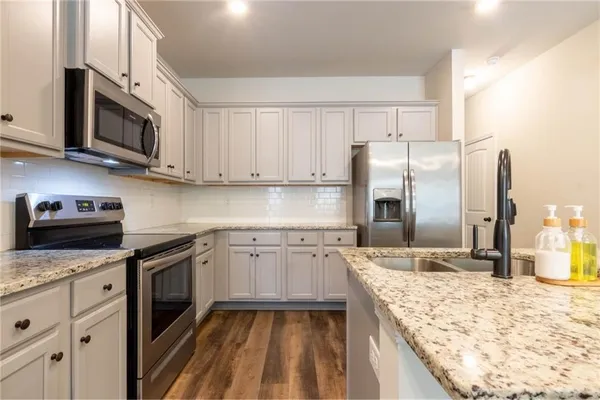 a kitchen with stainless steel appliances granite countertop a sink stove and refrigerator