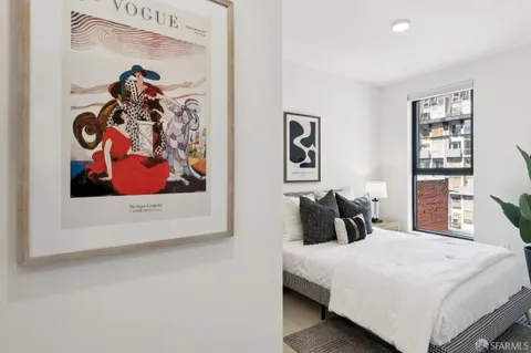 a bedroom with a bed and painting on the wall