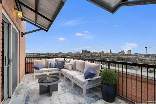 a roof deck with couches and wooden floor
