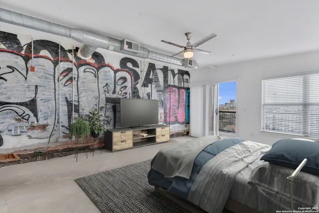 a bedroom with a bed couch and a flat screen tv