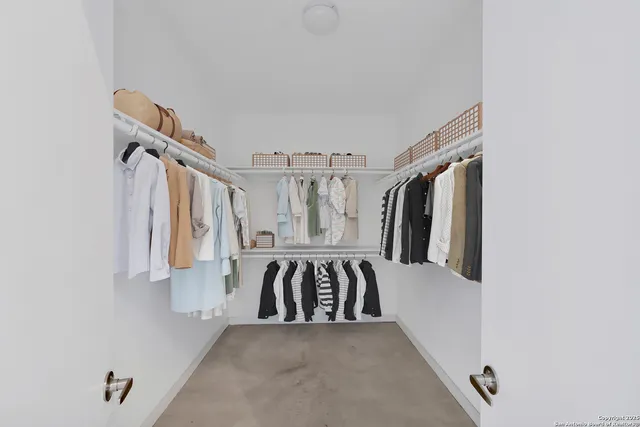 a view of walk in closet with clothes and shoes