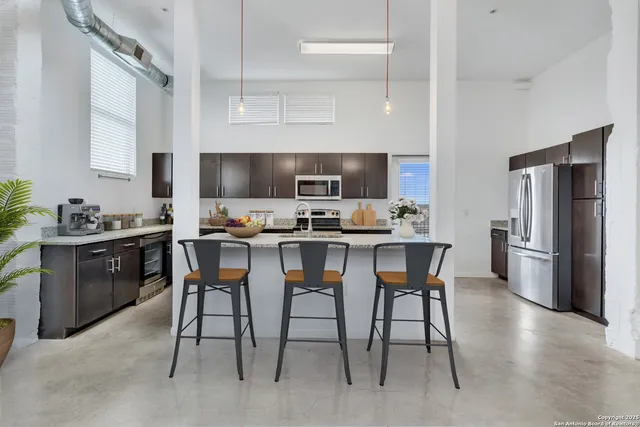 a kitchen with a dining table chairs and refrigerator